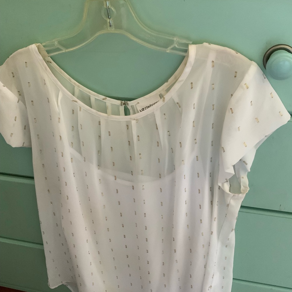 Sheer white blouse with gold accent.